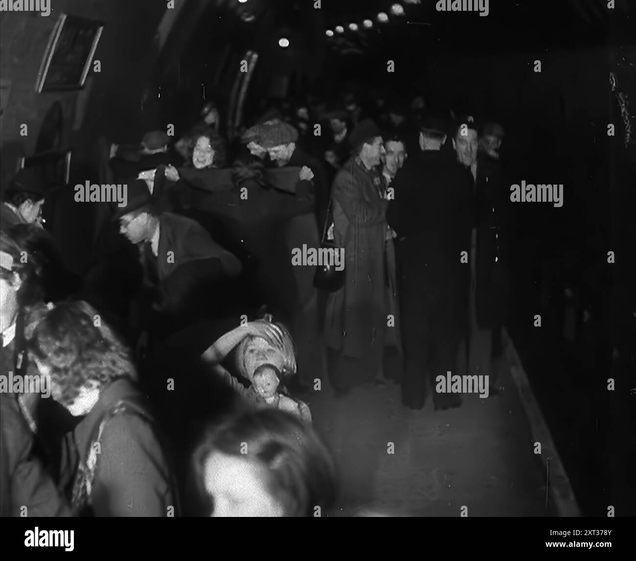 Civils à l'abri des bombes dans le métro de Londres, 1940. La Grande-Bretagne pendant la seconde Guerre mondiale : des civils à l'abri du Blitz de Londres. « Au-dessous de la plus grande ville du monde, un hôte s'installe pour dormir, au plus profond de la nuit effrayante [par exemple, les bombardements allemands]. Des terriers pour les êtres humains loin des bombes. De "Time to Remember - Standing Alone", 1940 (bobine 4) ; film documentaire sur les événements des derniers mois de 1940. Banque D'Images