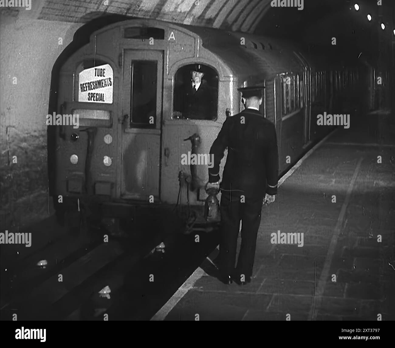 Arrêt d'un train de métro, 1940. La Grande-Bretagne pendant la seconde Guerre mondiale. "Rafraîchissements spéciaux" apporter de la nourriture et des boissons aux civils à l'abri du Blitz de Londres. « Au-dessous de la plus grande ville du monde, un hôte s'installe pour dormir, au plus profond de la nuit effrayante [par exemple, les bombardements allemands]. Des terriers pour les êtres humains loin des bombes. De "Time to Remember - Standing Alone", 1940 (bobine 4) ; film documentaire sur les événements des derniers mois de 1940. Banque D'Images