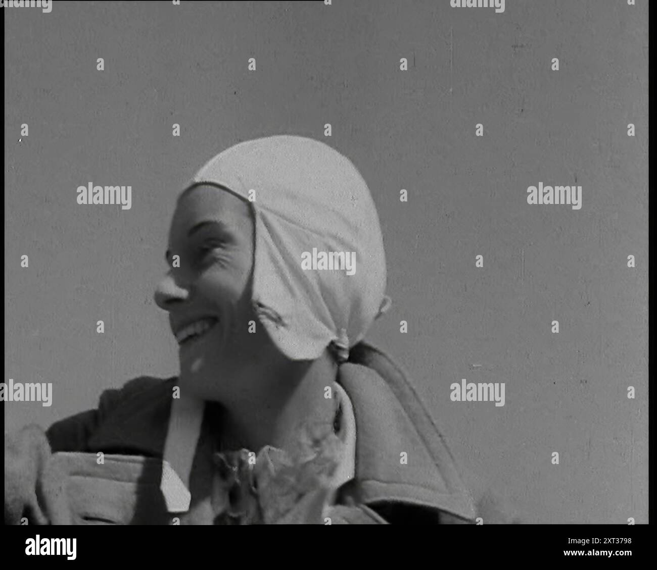 Jean Batten dans Flying Gear souriant aux foules, années 1930 De "Time to Remember - Some People in the Thirties", années 1930 (Reel 2) ; film documentaire sur les années 1930, mettant l'accent sur les personnages célèbres de l'époque. Banque D'Images