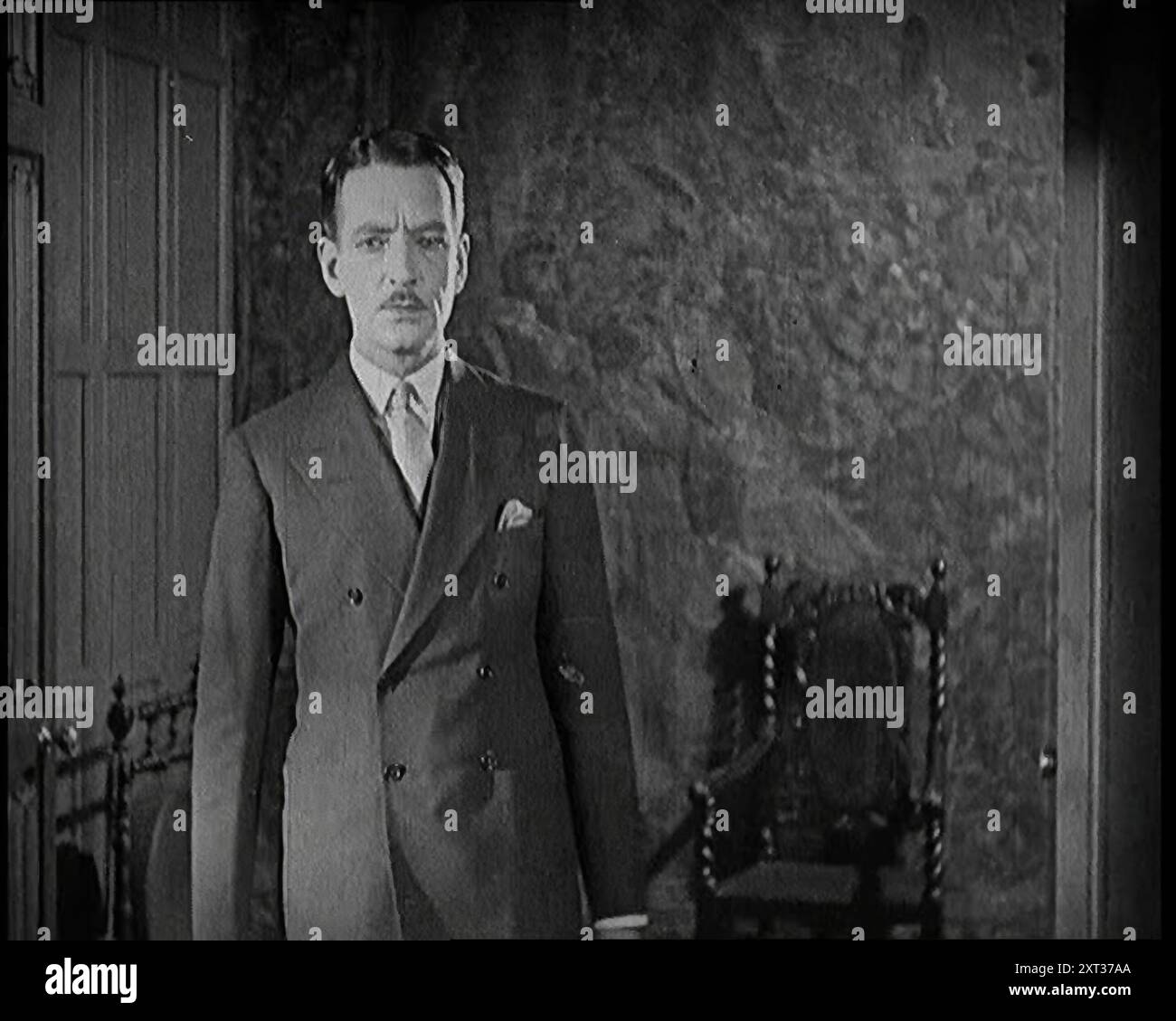 Extrait d'un film silencieux. Un acteur masculin entre par une porte, 1920s. «... nous avons créé notre fabrication de celluloïd non pas avec un écran large et un discours stéréophonique argenté, mais avec un simple mime et un silence doré ». De "Time to Remember - came the Dawn", 1925 (bobine 1) ; aperçu de l'industrie cinématographique britannique des années 1920 - extraits de grands films muets et de nouvelles. Banque D'Images