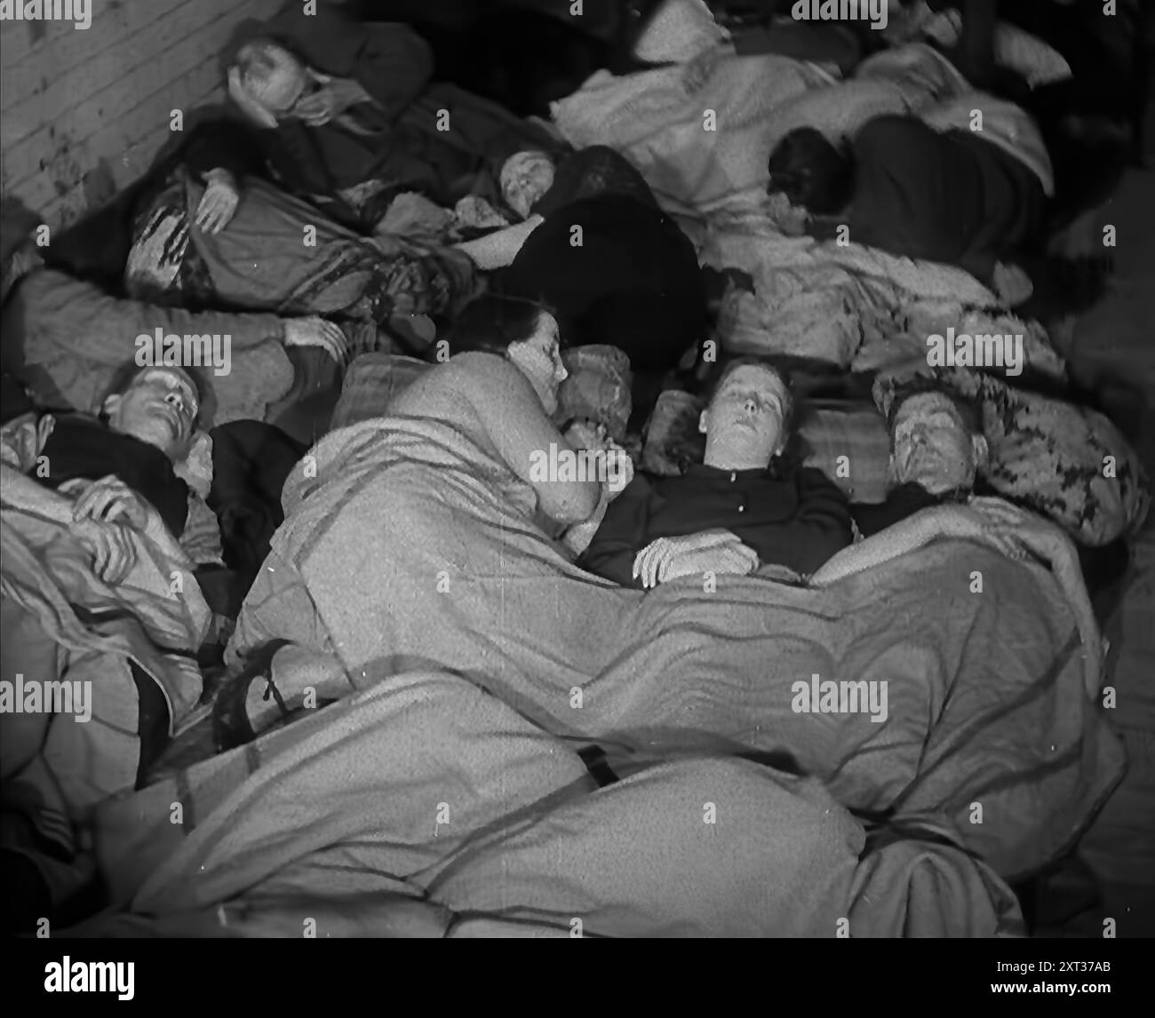 Civils dormant dans le métro londonien, 1940. La Grande-Bretagne pendant la seconde Guerre mondiale : les gens à l'abri du Blitz de Londres. « Au-dessous de la plus grande ville du monde, un hôte s'installe pour dormir, au plus profond de la nuit effrayante [par exemple, les bombardements allemands]. Des terriers pour les êtres humains loin des bombes et une pluie d'acier des armes bien intentionnées [c'est-à-dire britanniques]. De "Time to Remember - Standing Alone", 1940 (bobine 4) ; film documentaire sur les événements des derniers mois de 1940. Banque D'Images