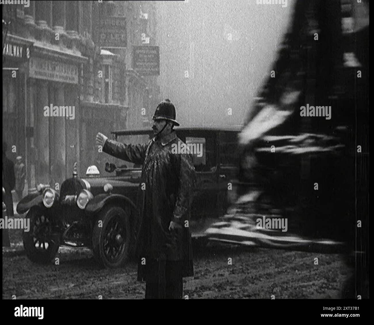 Un officier de police masculin dirigeant la circulation dans la neige, face à la caméra, années 1920 De "Time to Remember - came the Dawn", 1925 (bobine 1) ; aperçu de l'industrie cinématographique britannique des années 1920 - extraits de grands films muets et de nouvelles. Banque D'Images