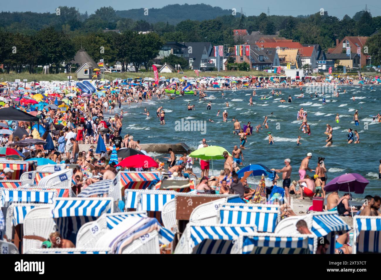Voller Sommerstrand in Scharbeutz Das Bild zeigt einen vollen Strand in Scharbeutz an der Ostseeküste an einem sonnigen heißen Sommertag. Der Strand ist dicht besetzt mit Strandkörben, bunten Sonnenschirmen und zahlreichen Badegästen, die das warme Wetter genießen. IM Wasser tummeln sich Menschen, die schwimmen oder einfach im seichten Wasser stehen. An vielen Orten in Deutschland könnte es heute der bislang heißeste Tag des Jahres werden. Scharbeutz Schleswig-Holstein Deutschland *** plage d'été complète à Scharbeutz L'image montre une plage complète à Scharbeutz sur la côte de la mer Baltique sur un chaud Banque D'Images