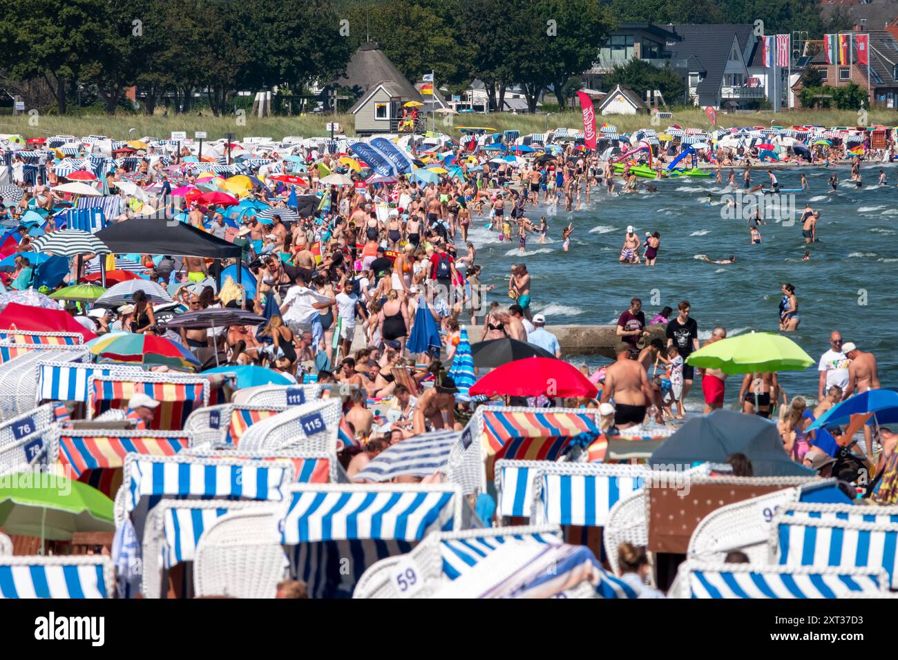 Voller Sommerstrand in Scharbeutz Das Bild zeigt einen vollen Strand in Scharbeutz an der Ostseeküste an einem sonnigen heißen Sommertag. Der Strand ist dicht besetzt mit Strandkörben, bunten Sonnenschirmen und zahlreichen Badegästen, die das warme Wetter genießen. IM Wasser tummeln sich Menschen, die schwimmen oder einfach im seichten Wasser stehen. An vielen Orten in Deutschland könnte es heute der bislang heißeste Tag des Jahres werden. Scharbeutz Schleswig-Holstein Deutschland *** plage d'été complète à Scharbeutz L'image montre une plage complète à Scharbeutz sur la côte de la mer Baltique sur un chaud Banque D'Images