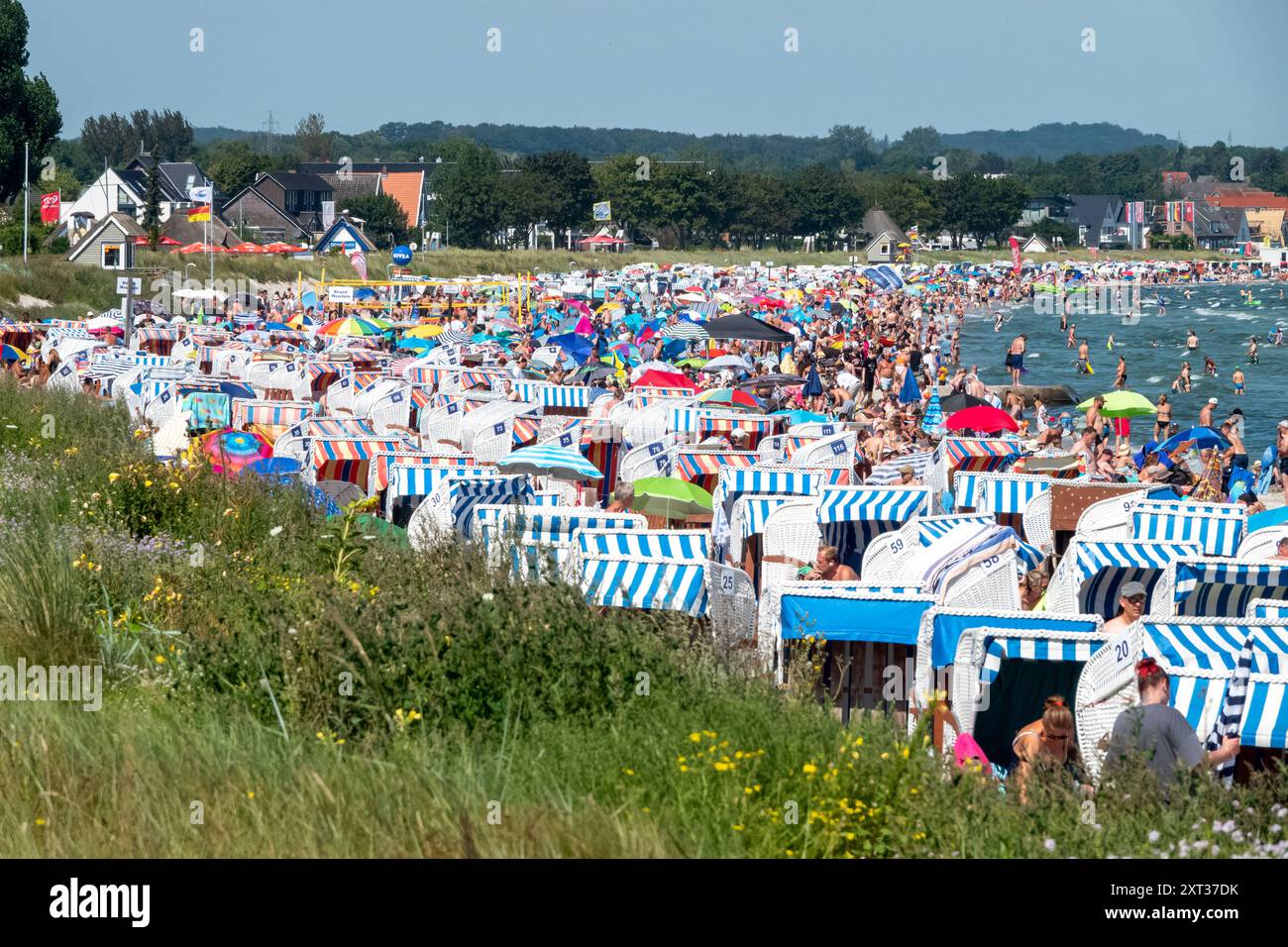 Voller Sommerstrand in Scharbeutz Das Bild zeigt einen vollen Strand in Scharbeutz an der Ostseeküste an einem sonnigen heißen Sommertag. Der Strand ist dicht besetzt mit Strandkörben, bunten Sonnenschirmen und zahlreichen Badegästen, die das warme Wetter genießen. IM Wasser tummeln sich Menschen, die schwimmen oder einfach im seichten Wasser stehen. An vielen Orten in Deutschland könnte es heute der bislang heißeste Tag des Jahres werden. Scharbeutz Schleswig-Holstein Deutschland *** plage d'été complète à Scharbeutz L'image montre une plage complète à Scharbeutz sur la côte de la mer Baltique sur un chaud Banque D'Images