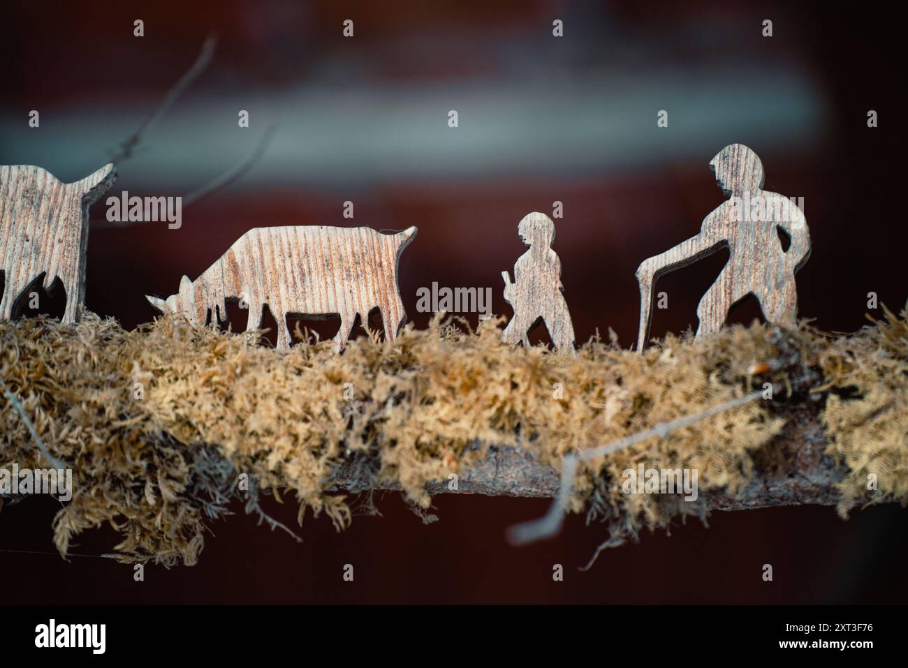 Cette image présente des figures en bois finement sculptées représentant une famille et des animaux typiques d'une scène hivernale suisse. Le décor présente des cra détaillées Banque D'Images