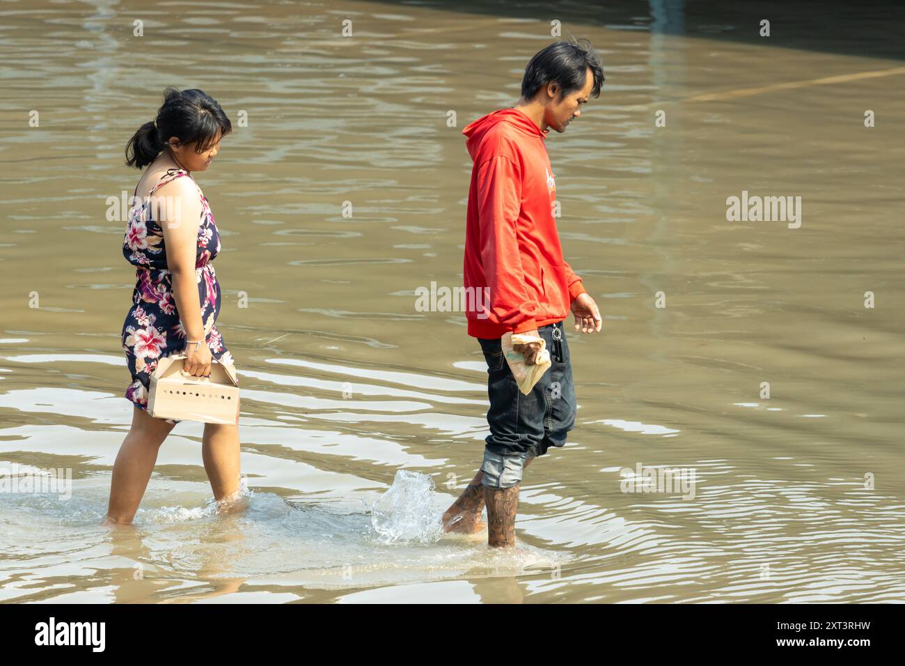 SAMUT PRAKAN, THAÏLANDE, février 02 2024, Un couple patente dans une rue inondée Banque D'Images