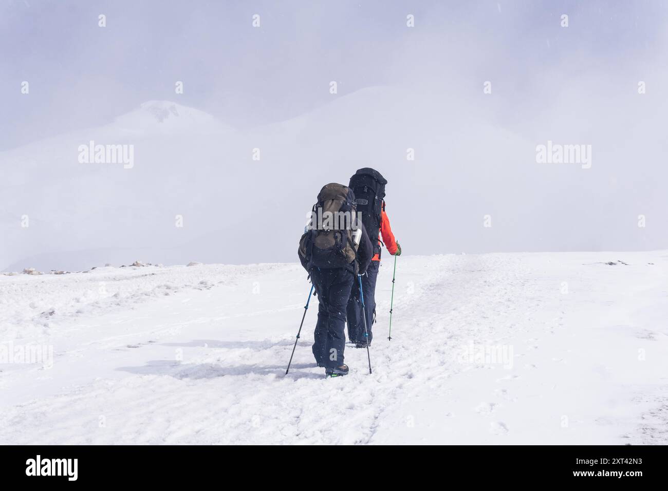 grimpeurs grimpe un sommet de montagne enneigé Banque D'Images
