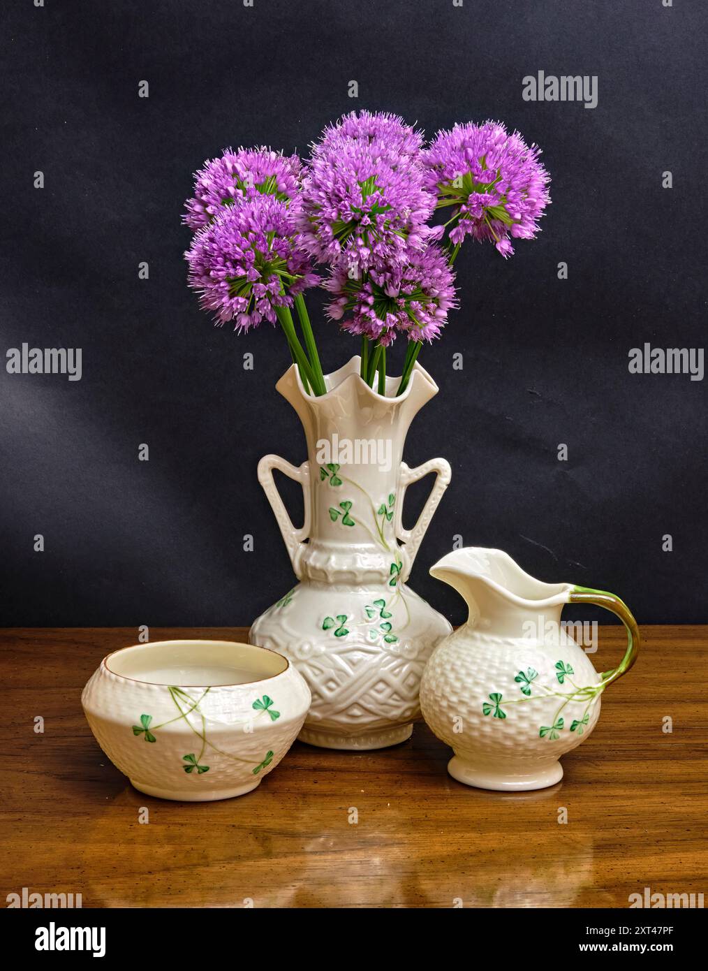 Purple sensation allium. Dans un beau blanc avec des trèfles vertes vase Beleek avec un sucre et des supports de lait. Fabriqué en Irlande. Banque D'Images