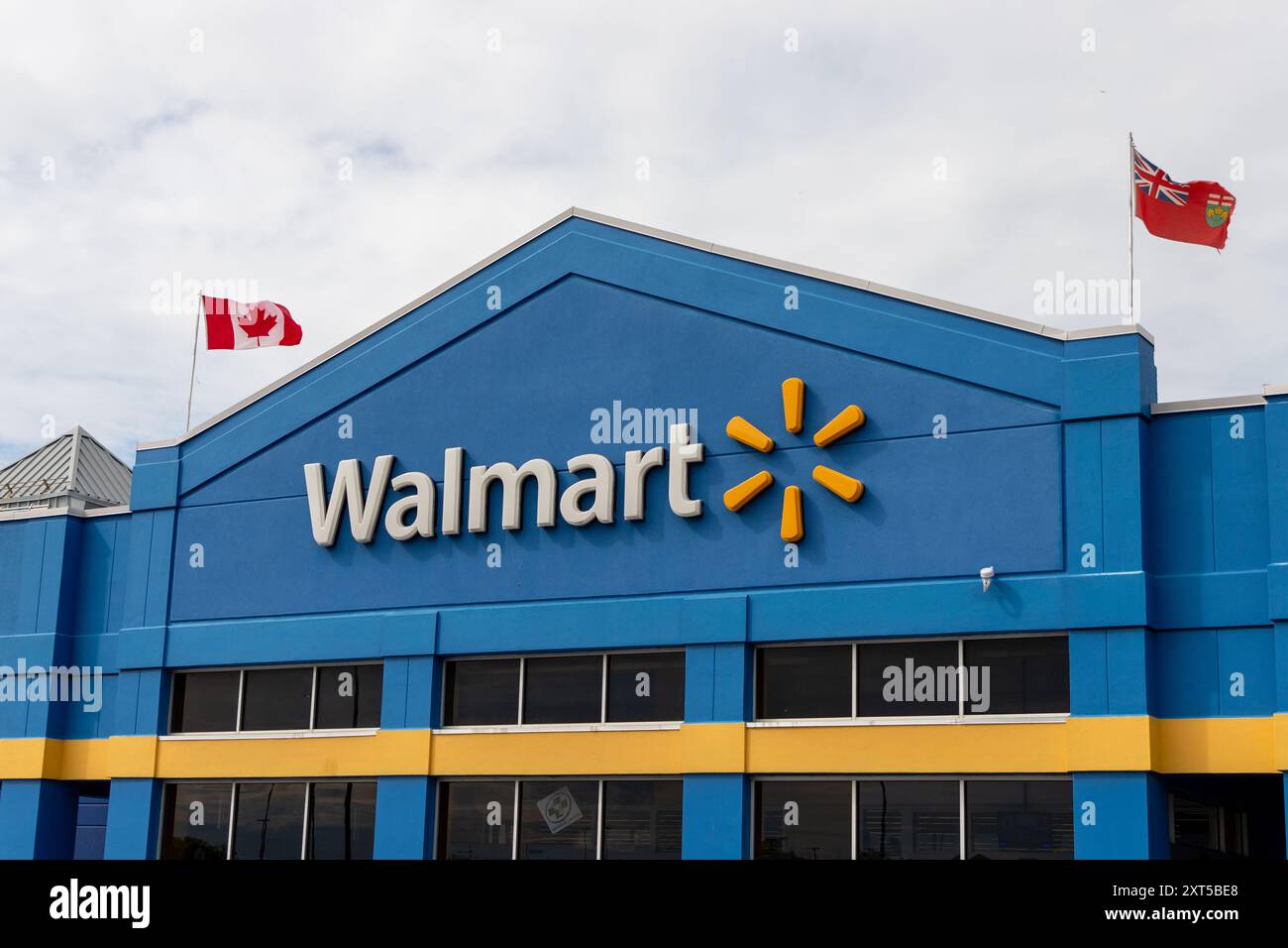 Kanata, Canada - 2 juin 2024 : immeuble de magasins de détail Walmart avec drapeaux canadiens et ontariens Banque D'Images