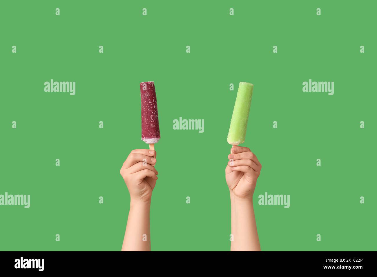 Mains féminines avec différentes glaces sucrées sur fond vert Banque D'Images