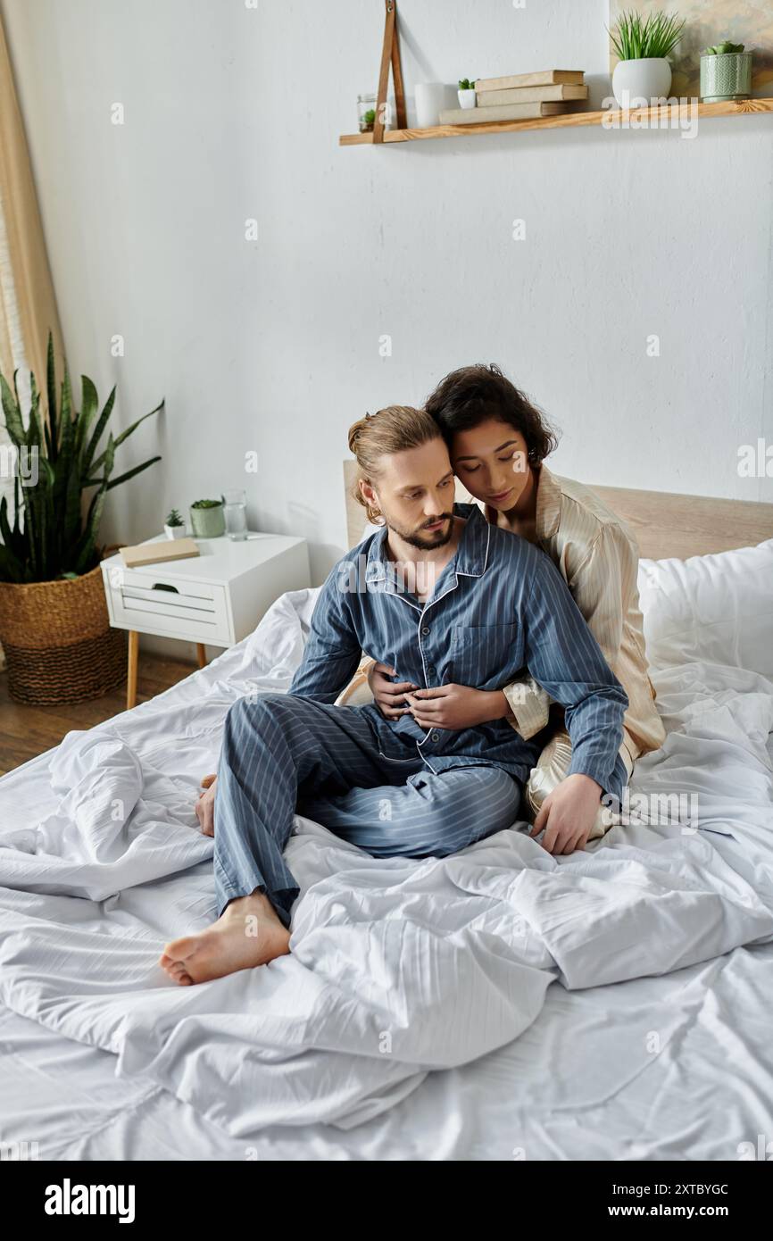 Un couple aimant se détend sur leur lit dans leur maison, profitant d'un moment de paix ensemble. Banque D'Images