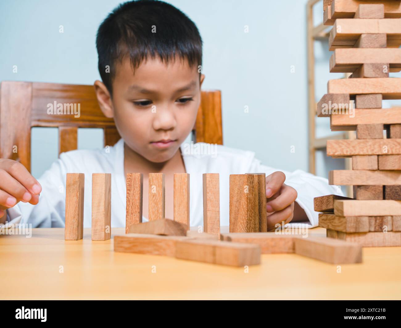 Joyeux garçon asiatique jouant avec des blocs de construction en bois Jenga, s'amuser et apprendre la créativité, concept d'enfant intelligent, bloc en bois planification, risque et s. Banque D'Images