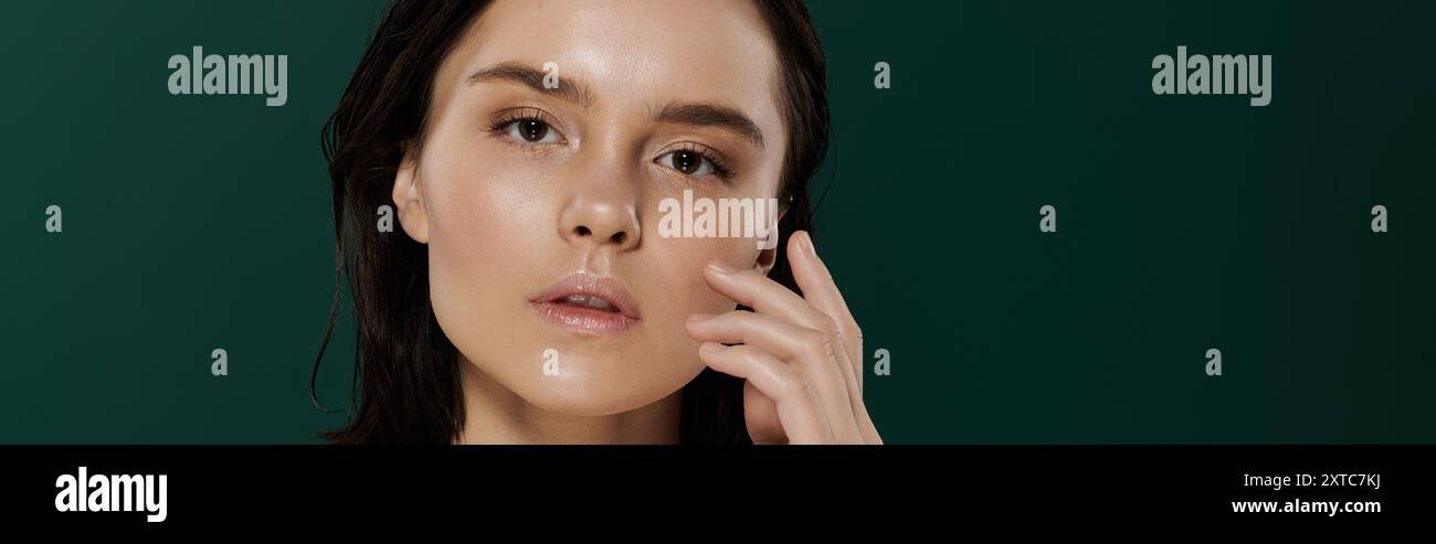 Une femme aux cheveux foncés pose devant un fond vert éclatant. Banque D'Images