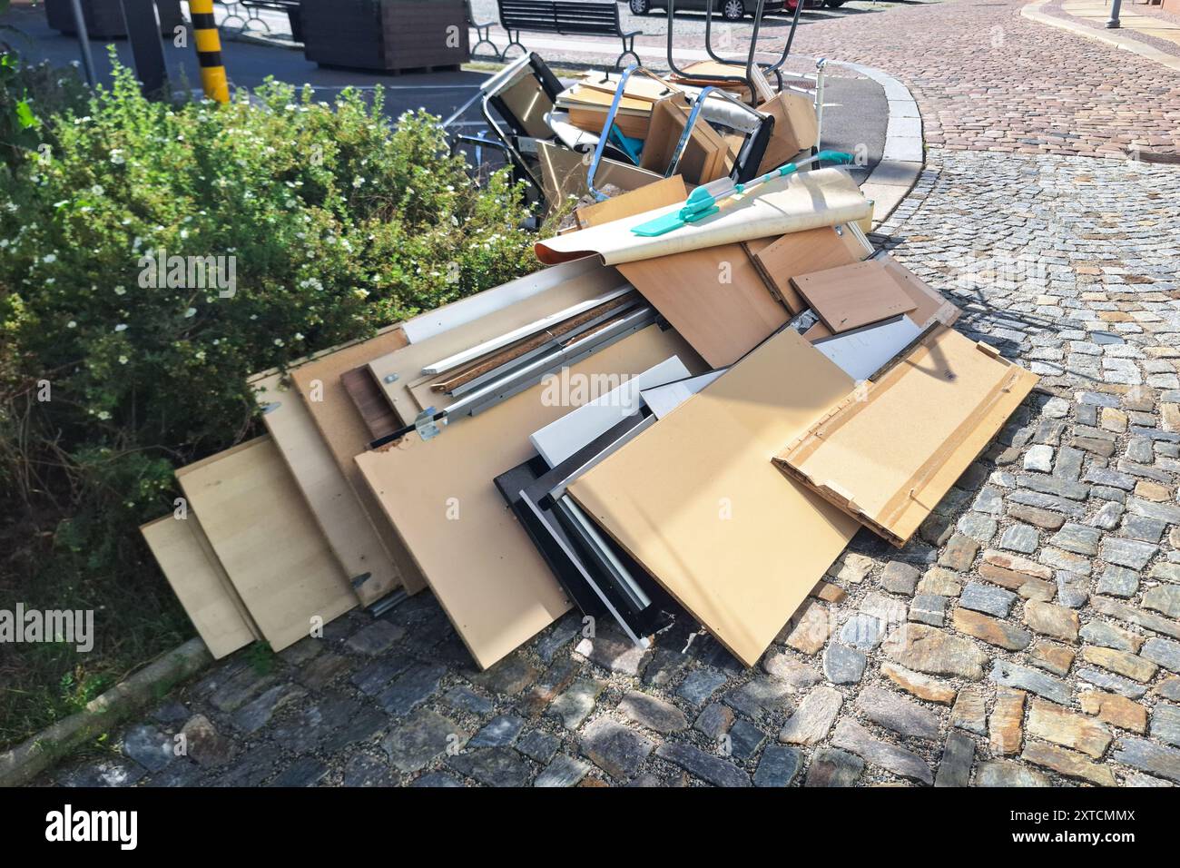 Un tas d'articles ménagers et de meubles jetés assortis empilés sur une rue pavée, représentant une journée de collecte des déchets en vrac dans une ville Banque D'Images