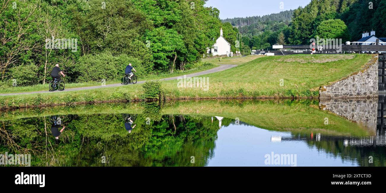 Cyclistes à côté des portes d'écluse au bassin de Crinan sur le canal de Crinan Argyll Écosse Banque D'Images