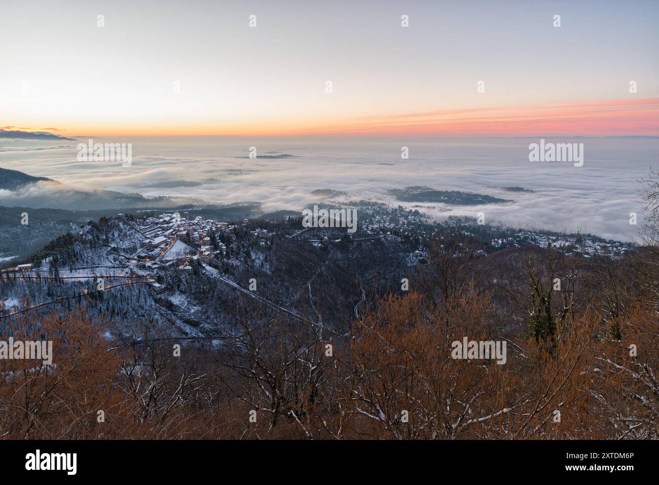 Ancien village perché avec une mer de nuages en dessous, au lever du soleil. Sacro Monte di Varese (site de l'UNESCO) avec la ville de Varèse dans le brouillard, Italie Banque D'Images