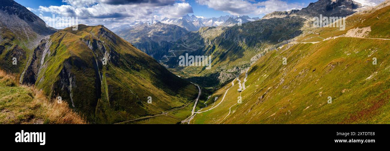 Vue panoramique sur le col sinueux de Furka en Suisse en été, mettant en valeur le paysage alpin luxuriant et les montagnes lointaines Banque D'Images