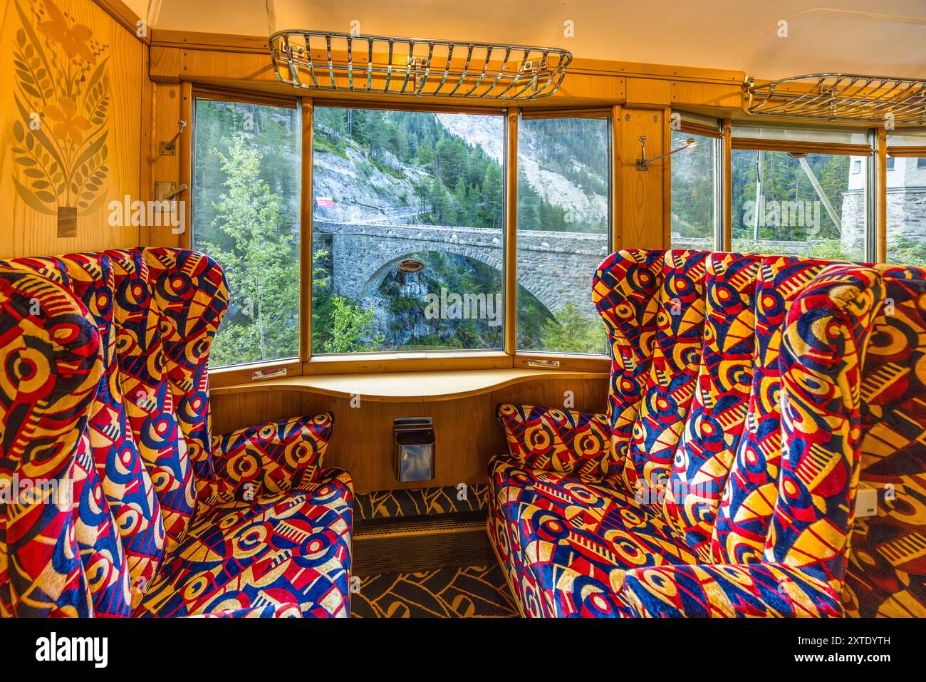 Un viaduc en pierre du chemin de fer rhétique traverse le paysage montagneux entre Davos Platz et Davos Wiesen, vu depuis la fenêtre de l'Alpine Classic Pullman Express. Le train date de 1931 et circulait à l'origine sous le nom de 'Golden Mountain Pullman Express' sur la ligne ferroviaire Montreux–Berner Oberland. Le chemin de fer rhétique l'a acheté en 1939 et l'a utilisé pour des voyages d'inspection de l'armée de 1940 jusqu'à la fin de la guerre. Le Verein Pro Salonwagen, fondé en 1998, a sauvé le train, qui est aujourd'hui un monument ferroviaire historique protégé dans le canton des Grisons. Talstrasse, Davos, Grisons, Suisse Banque D'Images