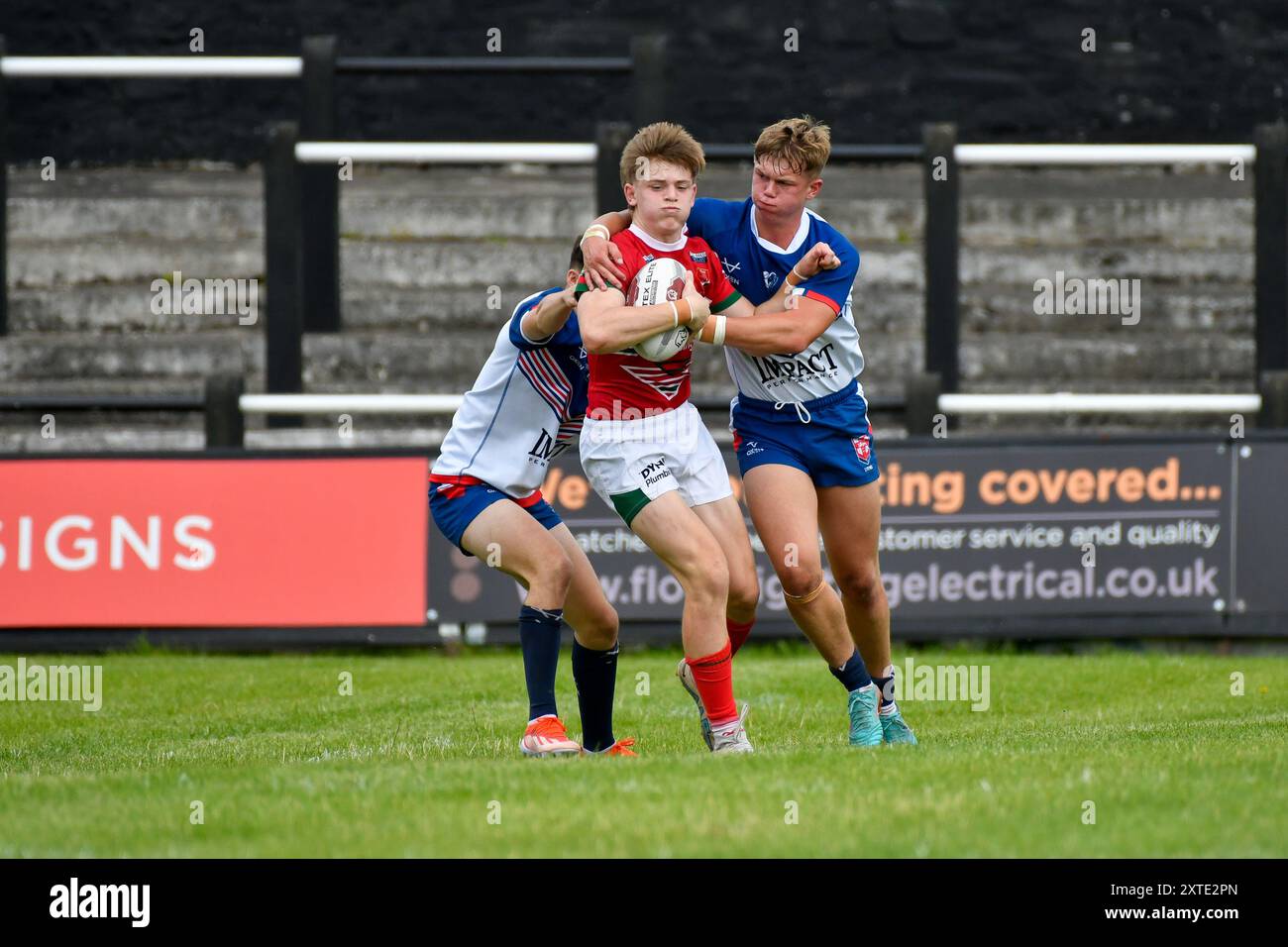 Neath, pays de Galles. 3 août 2024. Samuel Dickenson, du pays de Galles, est attaqué par deux joueurs des England Community Lions lors du match du Championnat des moins de 16 ans de rugby à XV entre le pays de Galles et les England Community Lions au Lextan Gnoll à Neath, au pays de Galles, au Royaume-Uni, le 3 août 2024. Crédit : Duncan Thomas/Majestic Media. Banque D'Images