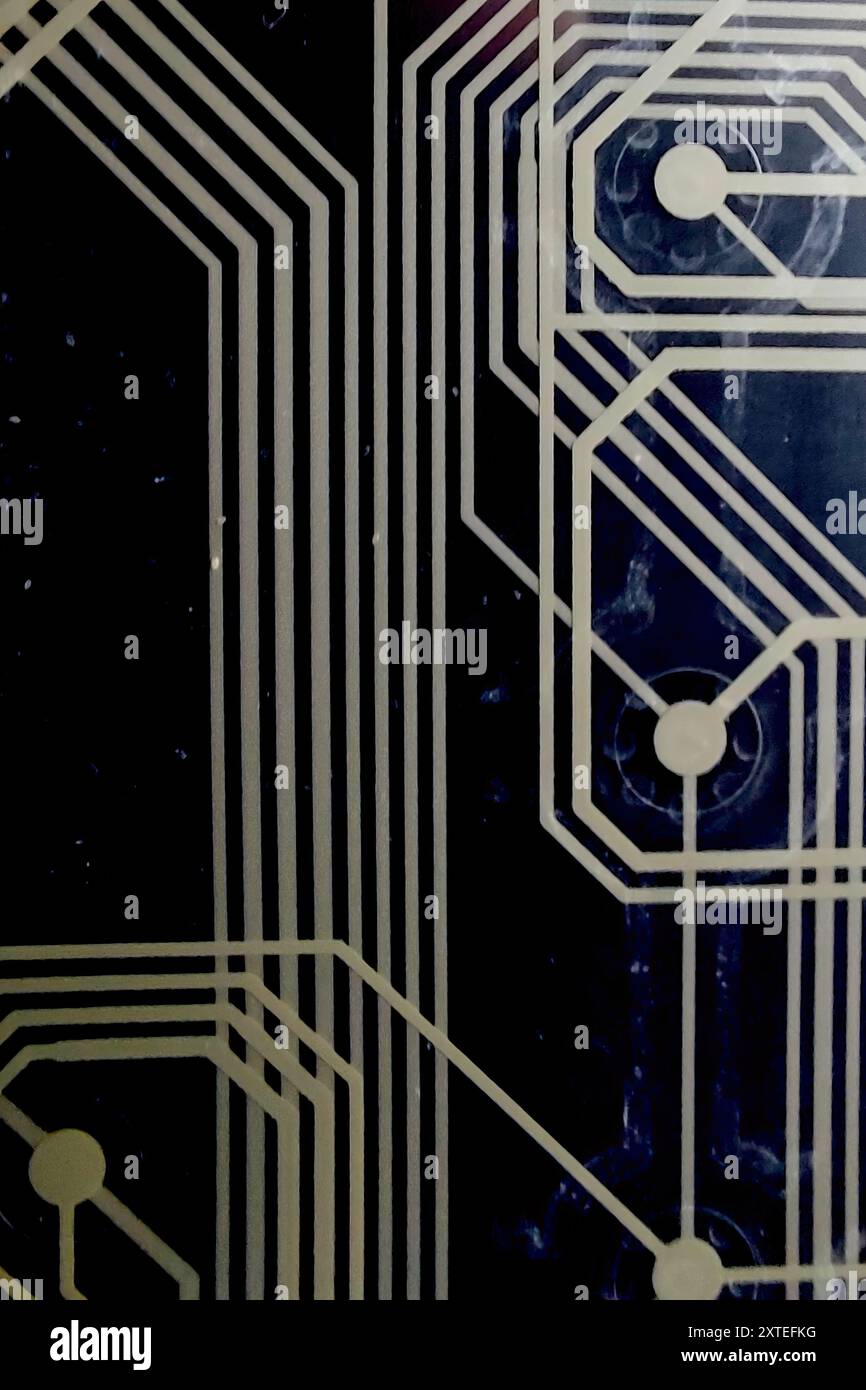 La carte de circuit imprimé détaillée présente des conceptions de câblage complexes sur un fond noir profond. Banque D'Images