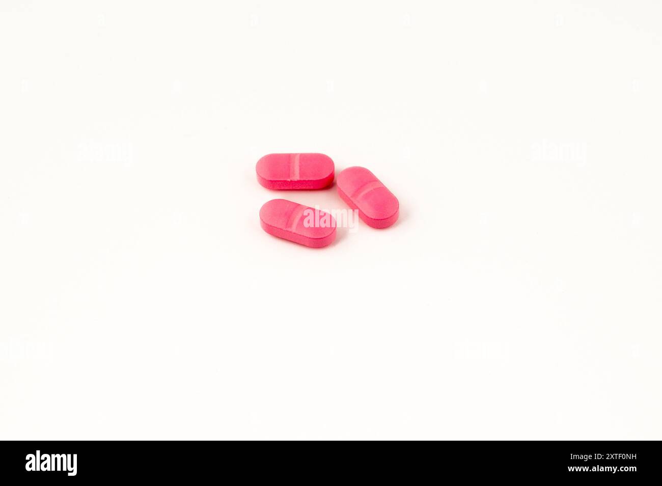 Concept regroupement de petites capsules de couleur rose sur fond blanc Banque D'Images