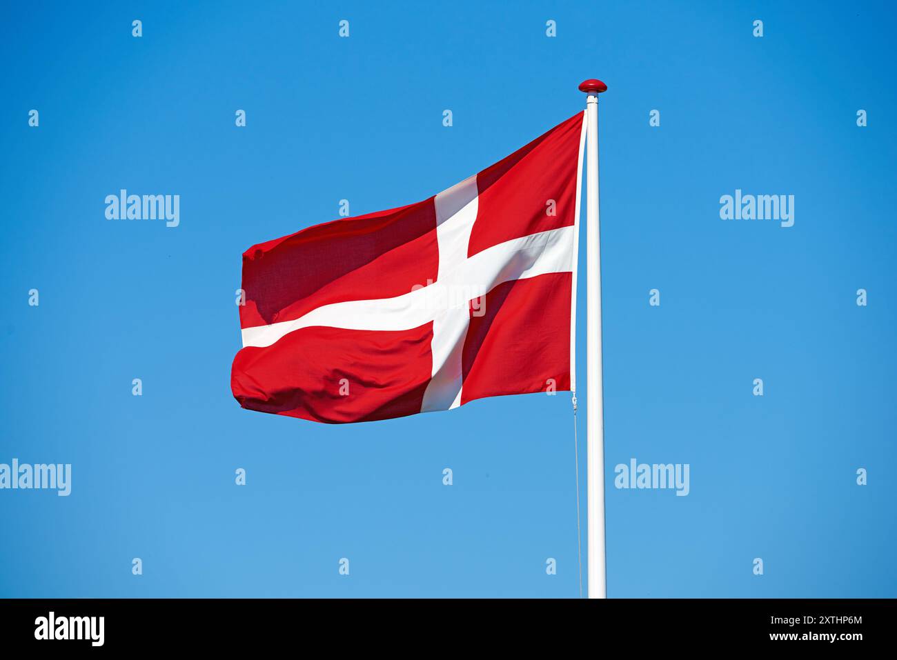 Drapeau, ciel bleu et danemark avec symbole de pays, scandinave ou état danois avec croix rouge et blanche. Vent, poteau ou représentation colorée de Banque D'Images