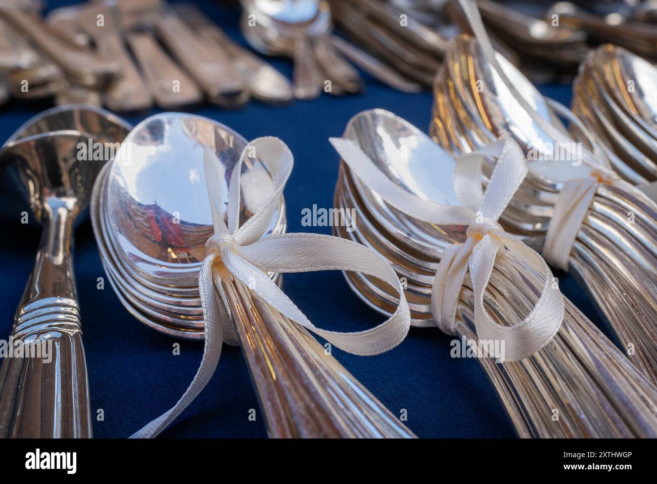 Argenterie à vendre au Mercatino dell'Antiquariato, le célèbre marché aux puces, Venise. Cuillères en argent attachées ensemble avec un ruban crémeux. Banque D'Images