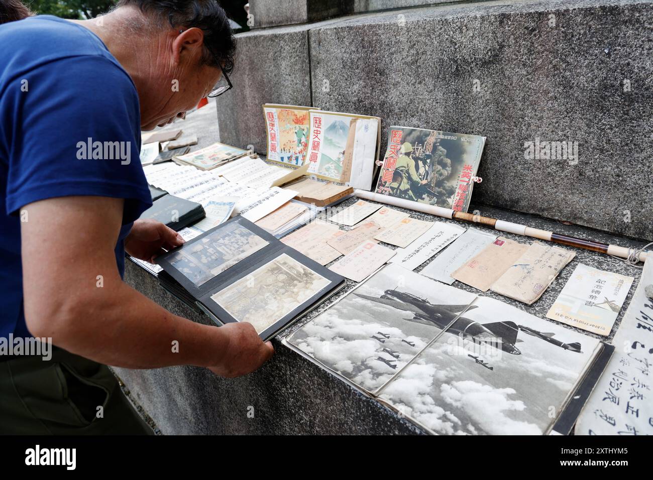 Tokyo, Japon. 15 août 2024. Un homme regarde de vieilles photos de la seconde Guerre mondiale devant le sanctuaire Yasukuni de Tokyo à l'occasion du 79e anniversaire de la reddition du Japon dans la seconde Guerre mondiale. Le premier ministre Fumio Kishida n'était pas parmi les législateurs à visiter le sanctuaire et a plutôt envoyé une offre rituelle pour éviter de mettre en colère les pays voisins qui associez également Yasukuni aux criminels de guerre et au passé impérial du Japon. (Crédit image : © Rodrigo Reyes Marin/ZUMA Press Wire) USAGE ÉDITORIAL SEULEMENT! Non destiné à UN USAGE commercial ! Banque D'Images