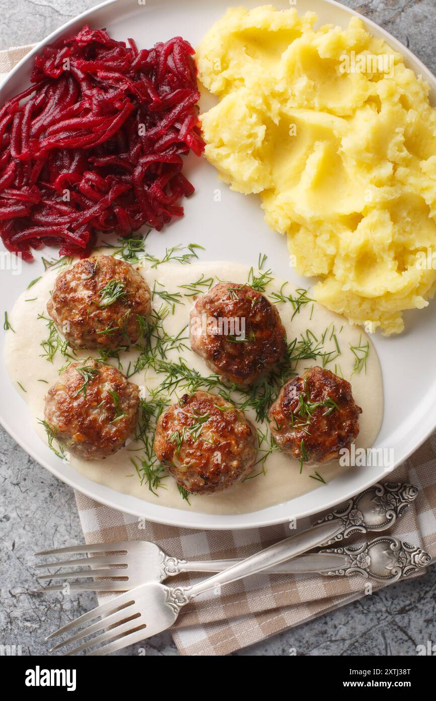 Boulettes de viande avec purée de pommes de terre et salade de betteraves gros plan dans une assiette sur la table. Vue de dessus verticale Banque D'Images