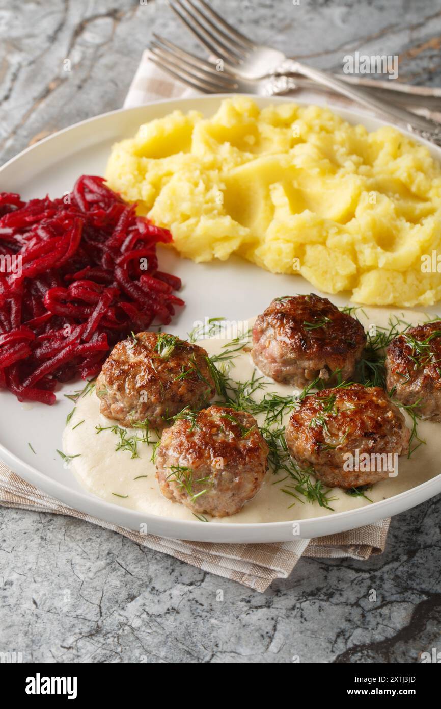 Boulettes de viande avec purée de pommes de terre et salade de betteraves gros plan dans une assiette sur la table. Vertical Banque D'Images