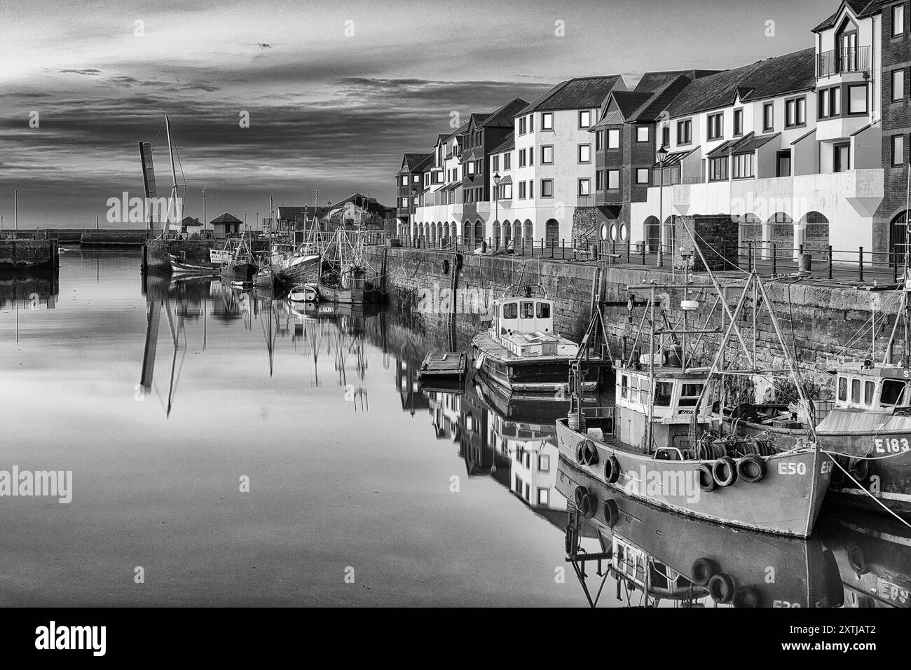 L'allure intemporelle des bateaux de pêche historiques de Maryport en noir et blanc dégage un sentiment de nostalgie et de patrimoine maritime Banque D'Images