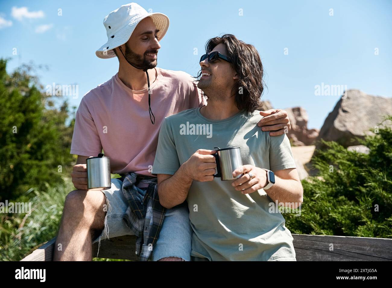 Un jeune couple gay profite d’une randonnée estivale dans la nature, partageant un moment d’amour et de connexion. Banque D'Images