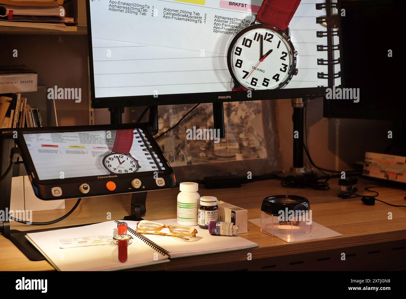 Vivre avec le handicap de la basse vision aidé avec des aides comme des loupes vidéo et des écrans d'ordinateur pour aider à lire les petits caractères sur les médicaments Banque D'Images