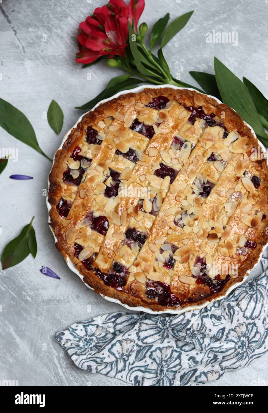 Délicieuse tarte maison avec des myrtilles et des amandes, des fleurs d'été et des feuilles sur fond clair, photo vue de dessus de l'article de pâtisserie frais Banque D'Images