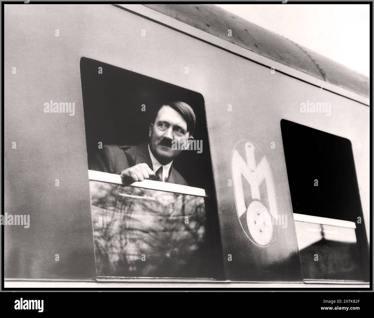 Adolf Hitler regarde par la fenêtre d'un wagon de train lors d'un voyage autour de l'Allemagne nazie. Propagande photo électorale pour promouvoir AdolfHitler et le parti nazi Allemagne photographe Heinrich Hoffmann/Studio de H. Hoffmann 1935 mai 25 Adolf Hitler : photos de la vie du leader - cigarettes/carte de promotion d'image Banque D'Images