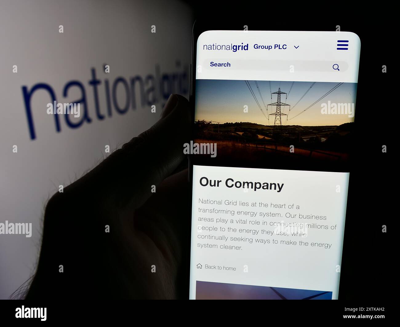 Personne tenant un smartphone avec le site Web de la société de services publics britannique National Grid plc devant le logo de l'entreprise. Concentrez-vous sur le centre de l'écran du téléphone. Banque D'Images