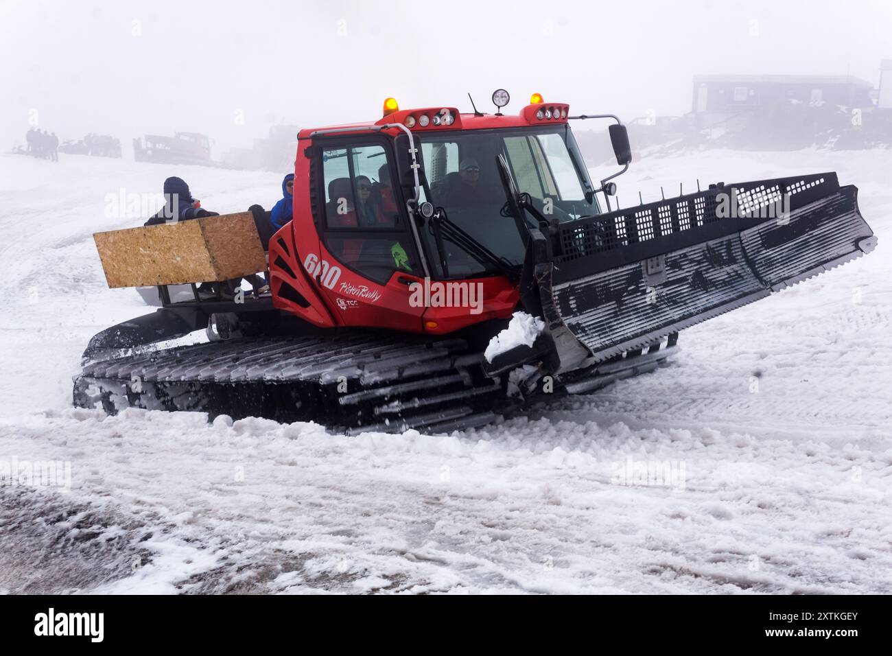 Elbrus, Russie - 01 août 2024 : transport de touristes à travers un glacier en fonte par un chat des neiges dans un nuage sur les pentes du mont Elbrus Banque D'Images