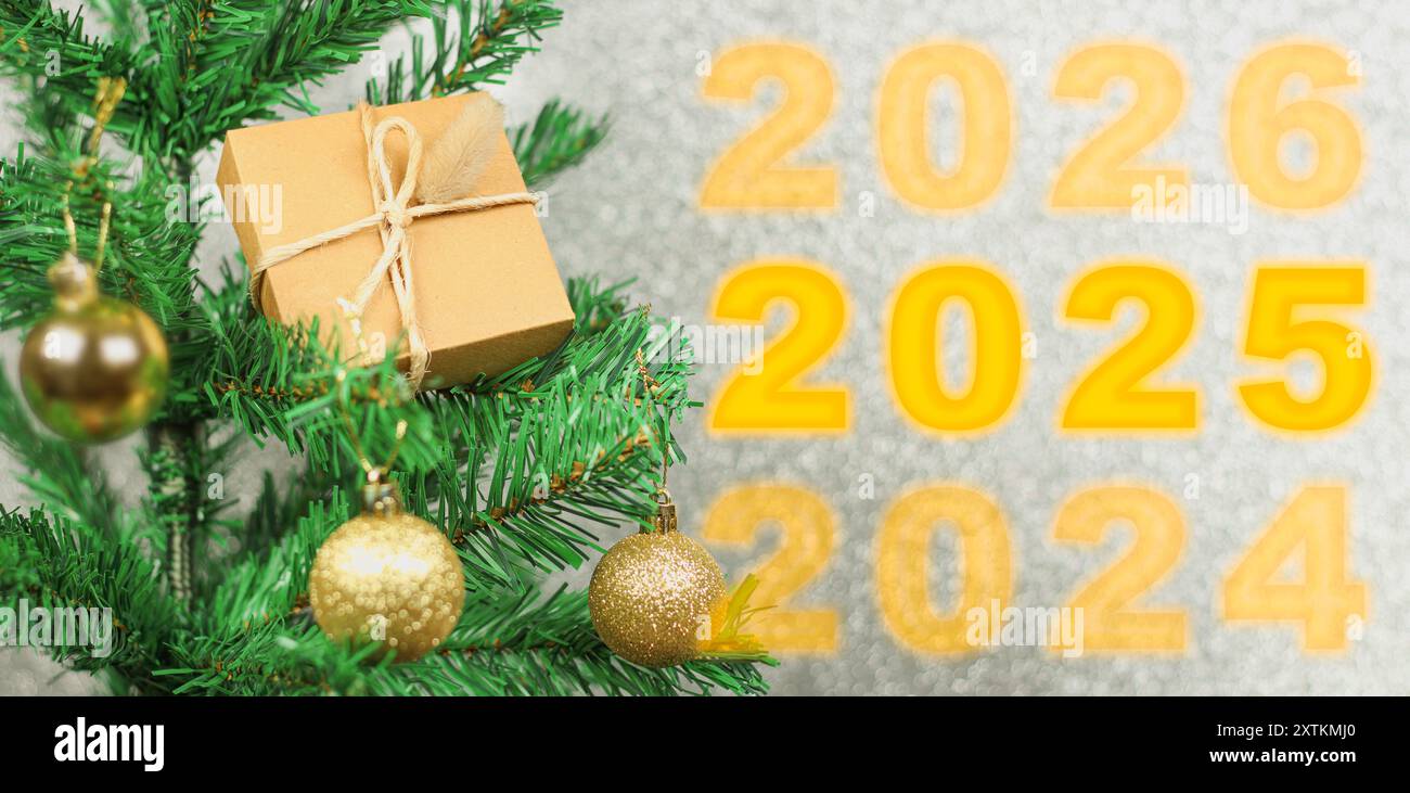 Bonne année 2025 anniversaire. Transition de 2024 à la nouvelle année 2025 image conceptuelle avec ornement de boule dorée sur l'arbre de Noël. Banque D'Images