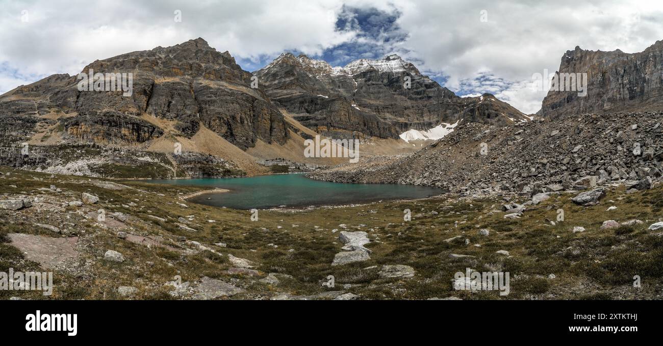 Une chaîne de montagnes avec un grand plan d'eau au premier plan. Le ciel est nuageux et les montagnes sont couvertes de neige Banque D'Images