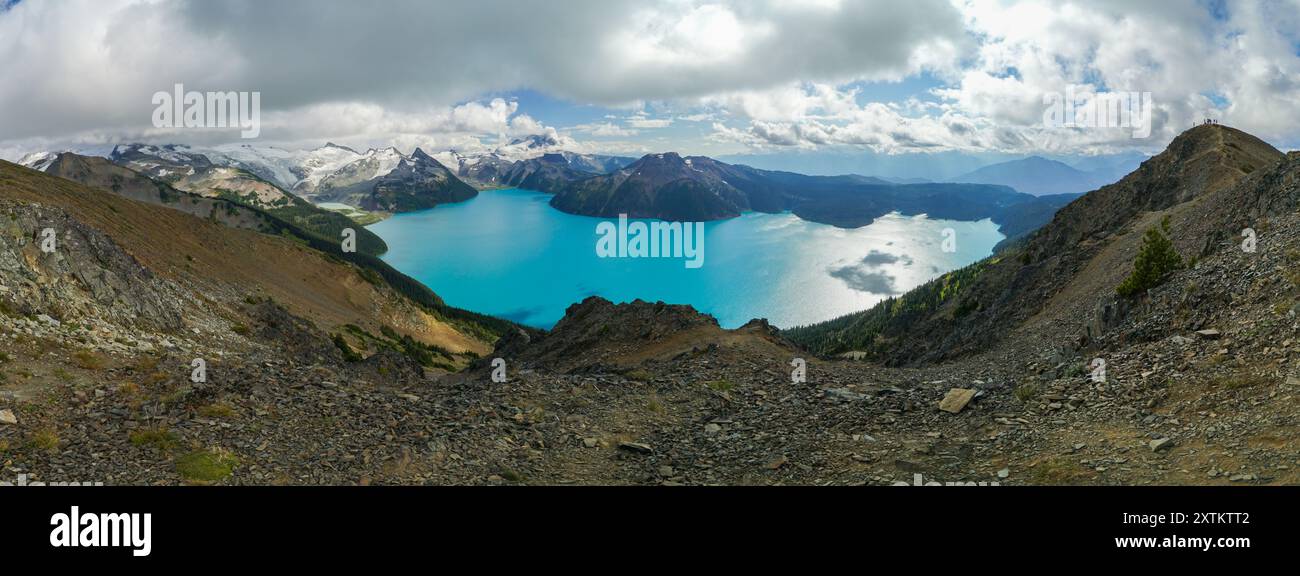 Une belle chaîne de montagnes avec un grand plan d'eau au premier plan. Le ciel est nuageux, mais l'eau est immobile et calme. La scène est sereine et p Banque D'Images