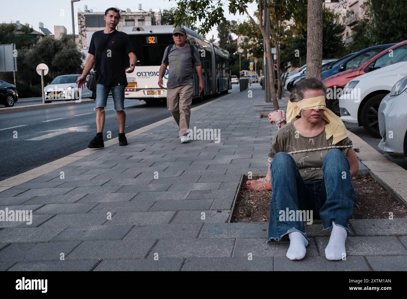 Jérusalem, Israël. 15 août 2024. Les activistes manifestent leur solidarité avec les otages israéliens à Gaza en se ligotant et en se bandant les yeux dans des lieux publics, des manifestations similaires apparaissant spontanément dans tout le pays. Les manifestants exigent un accord de libération immédiate des otages. Le conflit en cours entre Israël et le Hamas, déclenché par des tirs massifs de roquettes depuis Gaza et l’infiltration d’hommes armés palestiniens le 7 octobre 2023, a entraîné le massacre de 1 400 civils et l’enlèvement d’environ 240 personnes, dont des bébés, des enfants et des soldats. Avec 115 otages encore en captivité, beaucoup sont HOL Banque D'Images