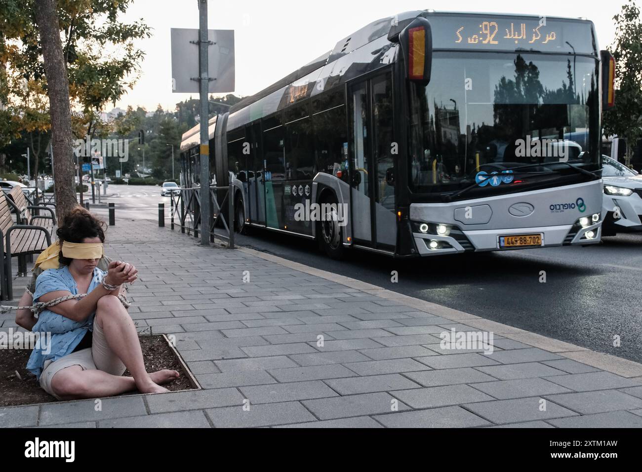 Jérusalem, Israël. 15 août 2024. Les activistes manifestent leur solidarité avec les otages israéliens à Gaza en se ligotant et en se bandant les yeux dans des lieux publics, des manifestations similaires apparaissant spontanément dans tout le pays. Les manifestants exigent un accord de libération immédiate des otages. Le conflit en cours entre Israël et le Hamas, déclenché par des tirs massifs de roquettes depuis Gaza et l’infiltration d’hommes armés palestiniens le 7 octobre 2023, a entraîné le massacre de 1 400 civils et l’enlèvement d’environ 240 personnes, dont des bébés, des enfants et des soldats. Avec 115 otages encore en captivité, beaucoup sont HOL Banque D'Images