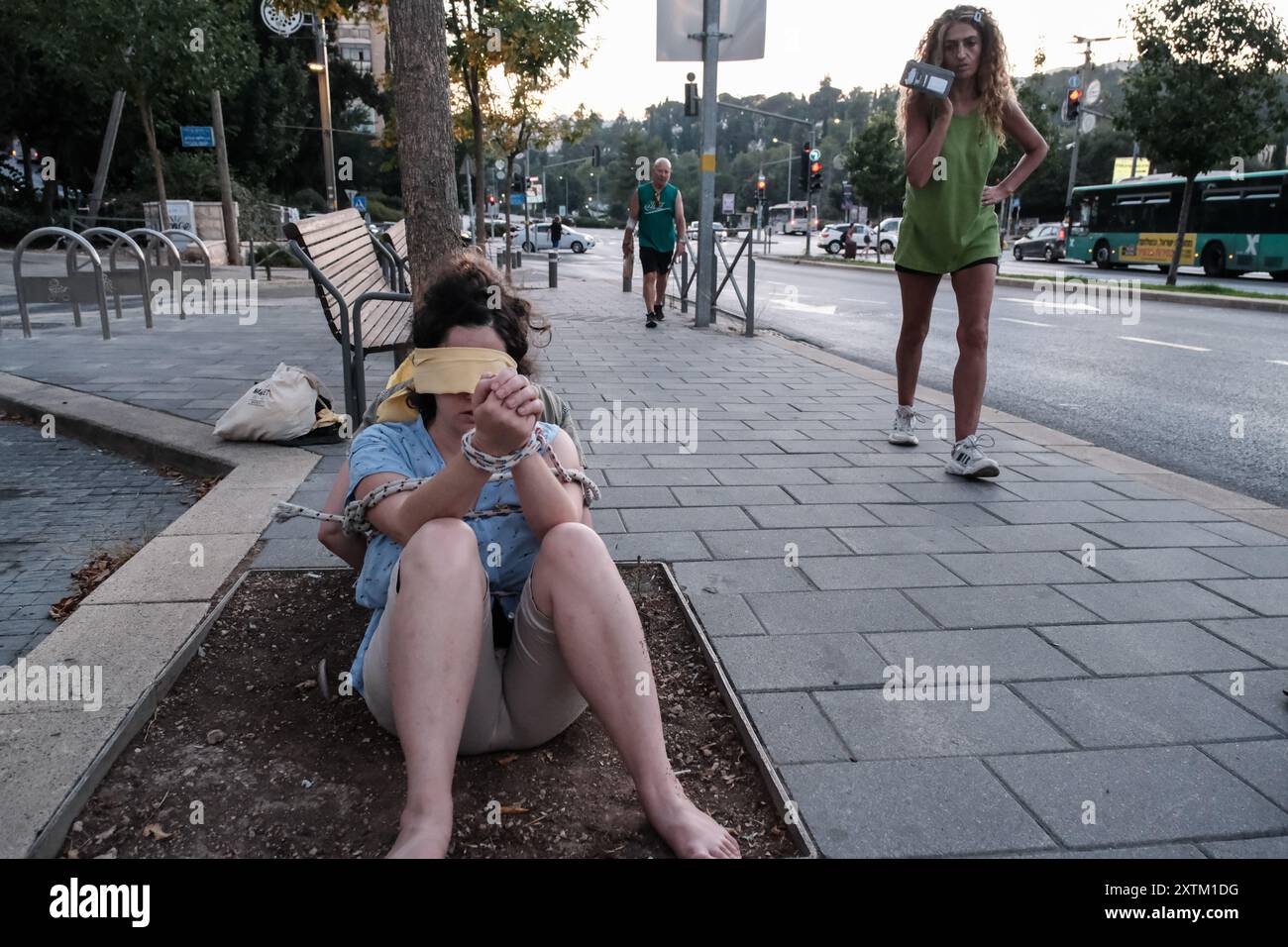 Jérusalem, Israël. 15 août 2024. Les activistes manifestent leur solidarité avec les otages israéliens à Gaza en se ligotant et en se bandant les yeux dans des lieux publics, des manifestations similaires apparaissant spontanément dans tout le pays. Les manifestants exigent un accord de libération immédiate des otages. Le conflit en cours entre Israël et le Hamas, déclenché par des tirs massifs de roquettes depuis Gaza et l’infiltration d’hommes armés palestiniens le 7 octobre 2023, a entraîné le massacre de 1 400 civils et l’enlèvement d’environ 240 personnes, dont des bébés, des enfants et des soldats. Avec 115 otages encore en captivité, beaucoup sont HOL Banque D'Images