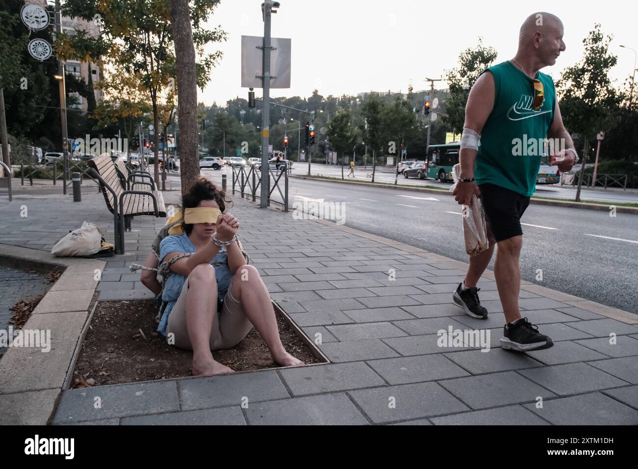Jérusalem, Israël. 15 août 2024. Les activistes manifestent leur solidarité avec les otages israéliens à Gaza en se ligotant et en se bandant les yeux dans des lieux publics, des manifestations similaires apparaissant spontanément dans tout le pays. Les manifestants exigent un accord de libération immédiate des otages. Le conflit en cours entre Israël et le Hamas, déclenché par des tirs massifs de roquettes depuis Gaza et l’infiltration d’hommes armés palestiniens le 7 octobre 2023, a entraîné le massacre de 1 400 civils et l’enlèvement d’environ 240 personnes, dont des bébés, des enfants et des soldats. Avec 115 otages encore en captivité, beaucoup sont HOL Banque D'Images