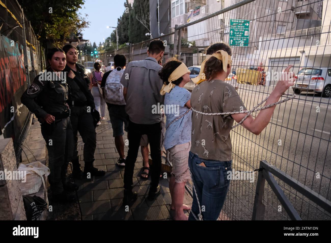 Jérusalem, Israël. 15 août 2024. Les activistes manifestent leur solidarité avec les otages israéliens à Gaza en se ligotant et en se bandant les yeux dans des lieux publics, des manifestations similaires apparaissant spontanément dans tout le pays. Les manifestants exigent un accord de libération immédiate des otages. Le conflit en cours entre Israël et le Hamas, déclenché par des tirs massifs de roquettes depuis Gaza et l’infiltration d’hommes armés palestiniens le 7 octobre 2023, a entraîné le massacre de 1 400 civils et l’enlèvement d’environ 240 personnes, dont des bébés, des enfants et des soldats. Avec 115 otages encore en captivité, beaucoup sont HOL Banque D'Images