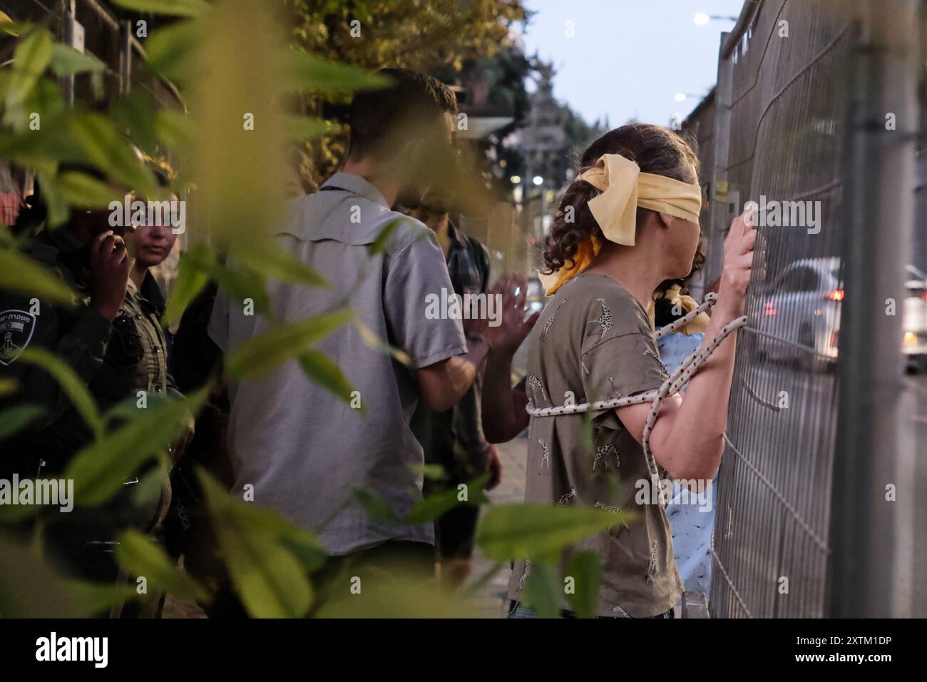 Jérusalem, Israël. 15 août 2024. Les activistes manifestent leur solidarité avec les otages israéliens à Gaza en se ligotant et en se bandant les yeux dans des lieux publics, des manifestations similaires apparaissant spontanément dans tout le pays. Les manifestants exigent un accord de libération immédiate des otages. Le conflit en cours entre Israël et le Hamas, déclenché par des tirs massifs de roquettes depuis Gaza et l’infiltration d’hommes armés palestiniens le 7 octobre 2023, a entraîné le massacre de 1 400 civils et l’enlèvement d’environ 240 personnes, dont des bébés, des enfants et des soldats. Avec 115 otages encore en captivité, beaucoup sont HOL Banque D'Images
