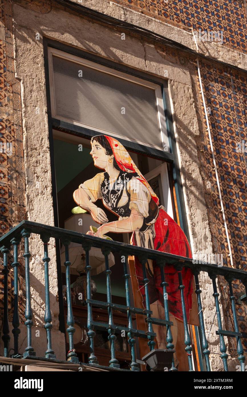 Découpe du dessin de femme en robe traditionnelle portugaise sur un balcon dans la vieille ville de Lisbonne au Portugal Europe Banque D'Images