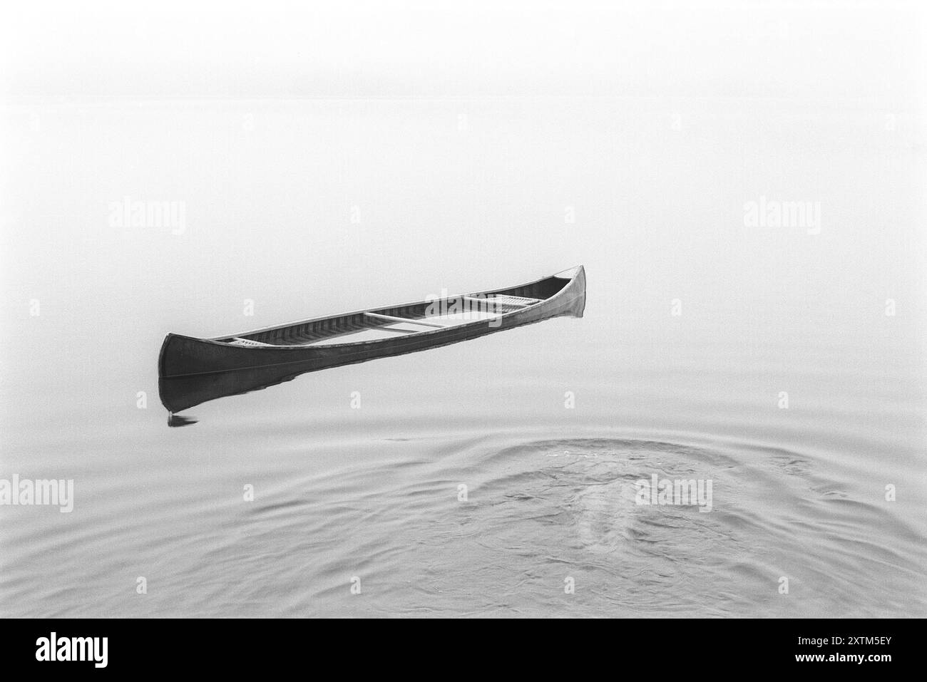 Personne méconnaissable nageant sous l'eau vers un canot inondé Banque D'Images