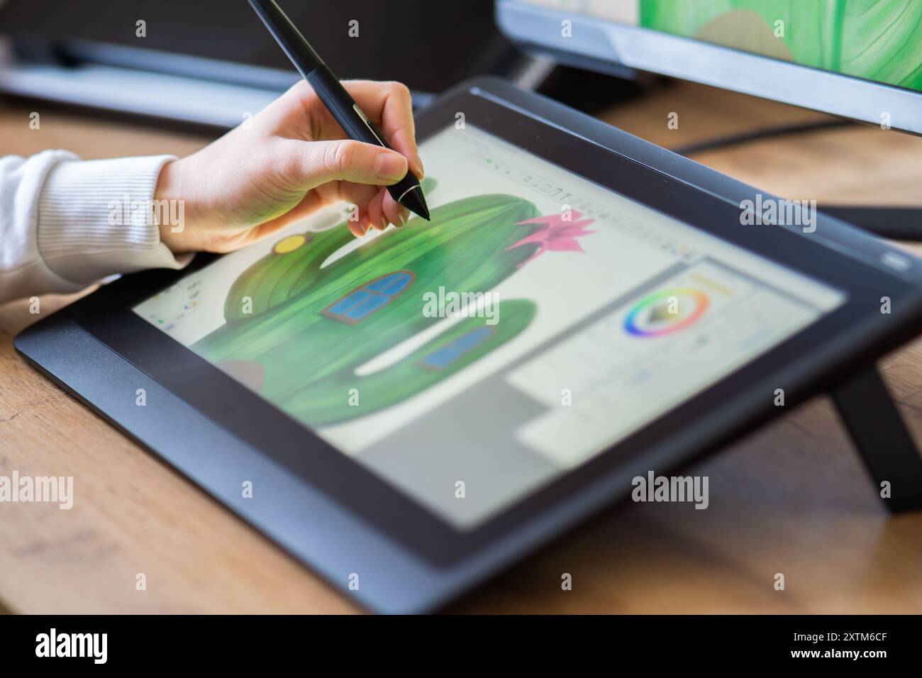 gros plan d'une main féminine dessinant sur une planche à dessin numérique. Graphiste travaillant à domicile Banque D'Images